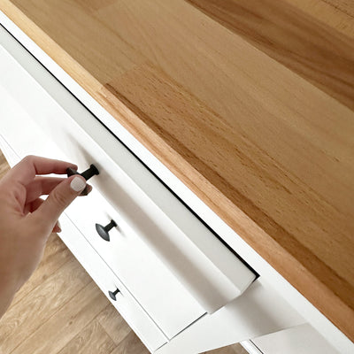 Detailansicht einer geölten Buchenholz Abdeckplatte, die auf einem weißen Ikea Schuhschrank liegt.