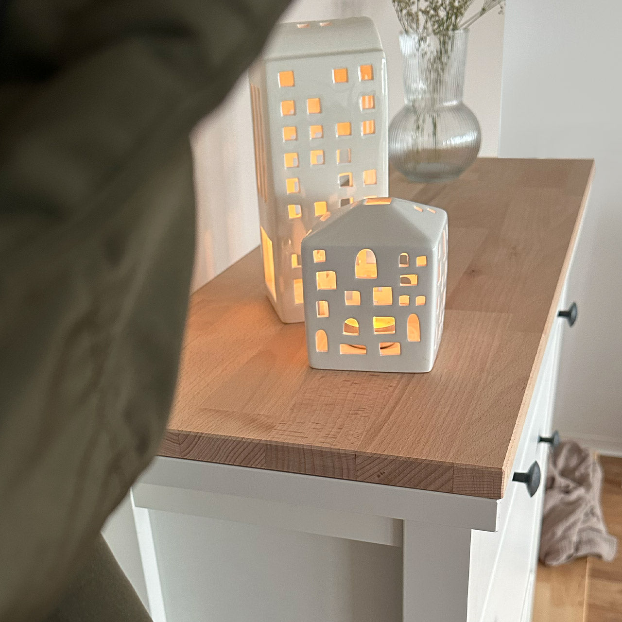 Detailansicht von einer natur belassenen Holzplatte aus Buchenholz, die auf einem weißen Ikea Hemnes Schuhschrank liegt.