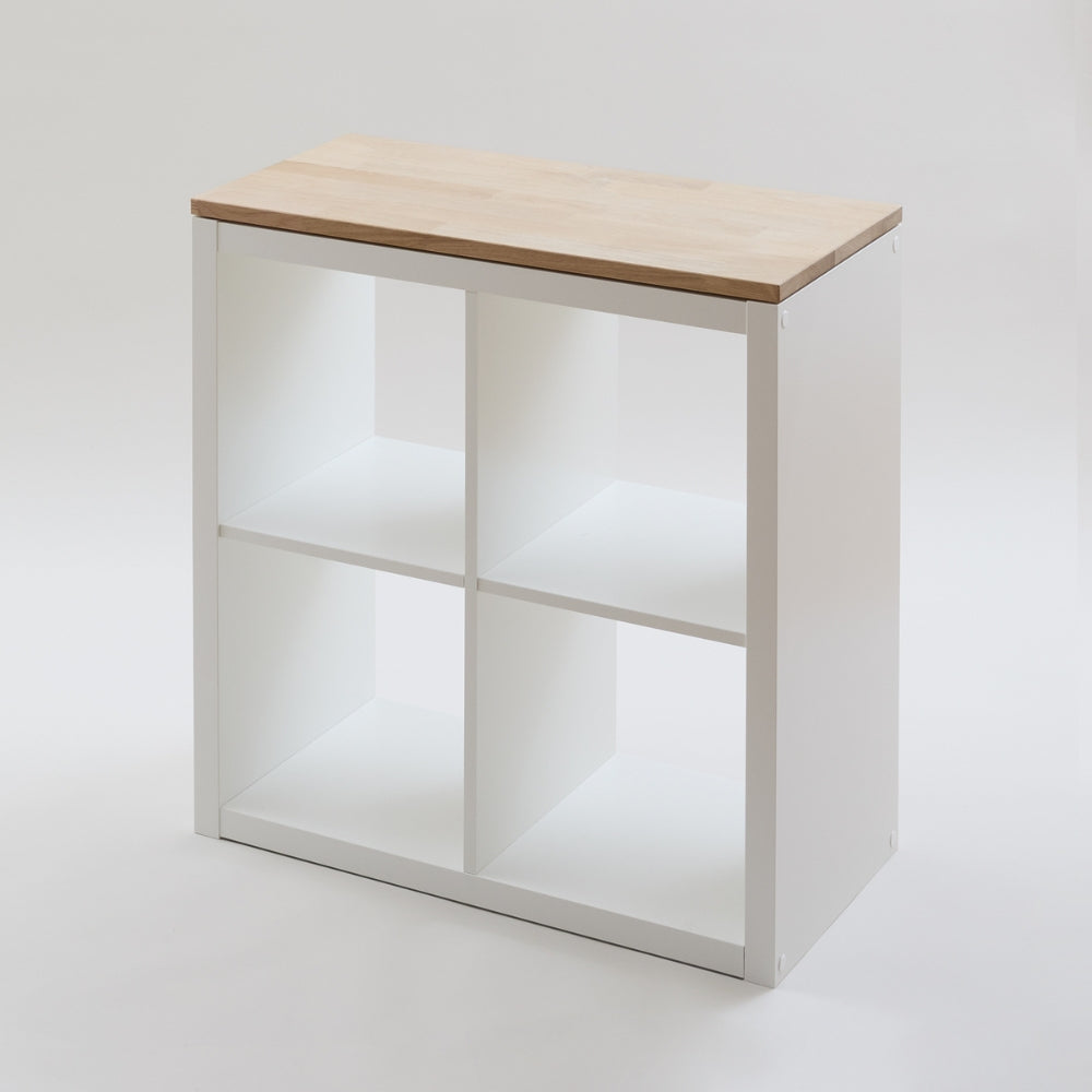Weißes Kallax Regal von IKEA mit 2 Fächern Breite (2x2) in einem weißen Studio. Auf dem Regal liegt eine passgenaue Massivholzplatte aus naturbelassener Eiche.