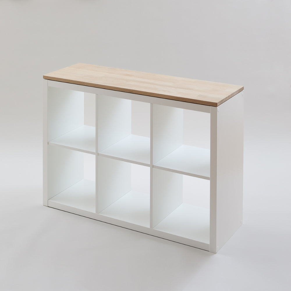 Weißes Kallax Regal von IKEA mit 3 Fächern Breite (3x2) in einem weißen Studio. Auf dem Regal liegt eine passgenaue Massivholzplatte aus naturbelassener Eiche.