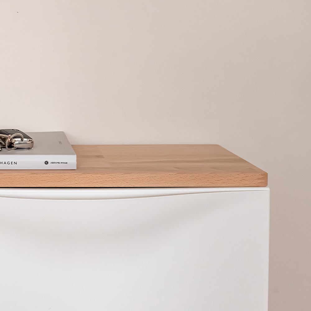 Detailansicht einer Buchenholzplatte, die auf einem weißen IKEA Trones Schuhschrank liegt.