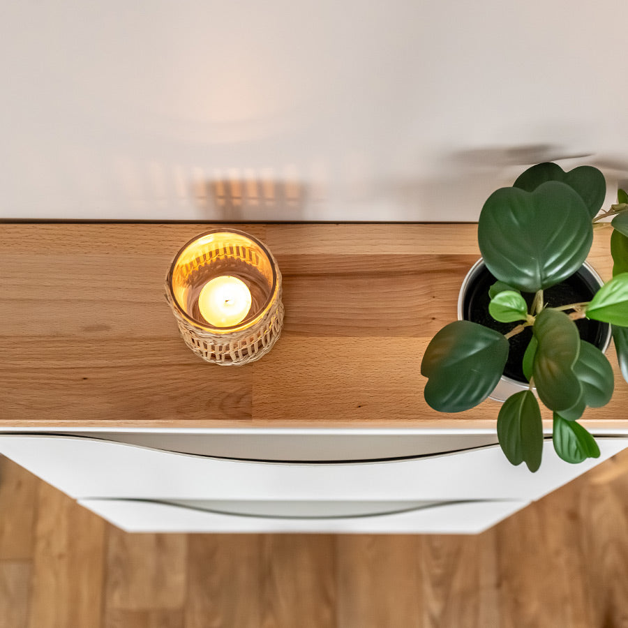 Detailansicht von einer Buchenholzplatte, die auf einem IKEA Schuhschrank liegt. Zudem sind ein Windlicht und eine Pflanze zu sehen.
