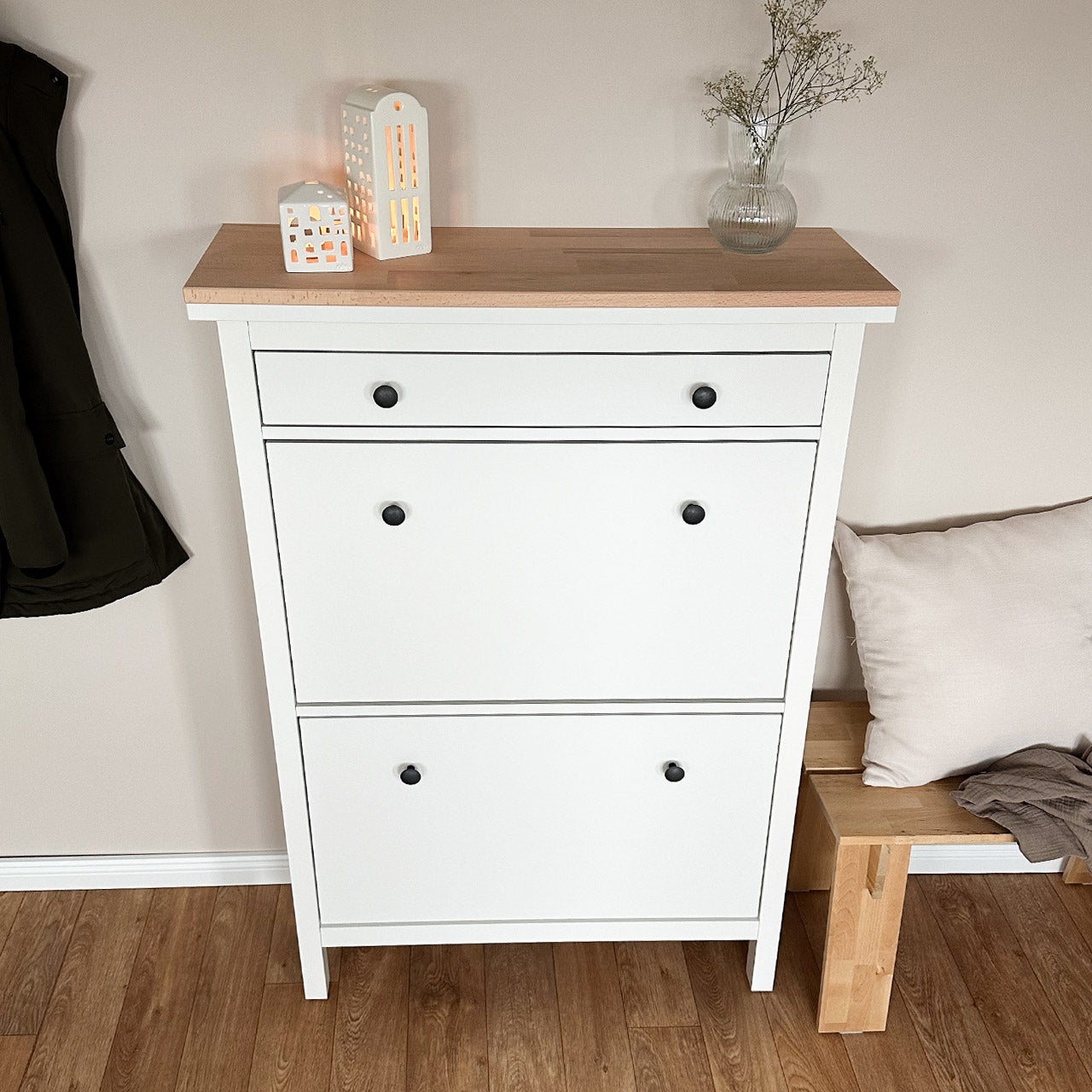 Frontalansicht von einem weißen Ikea Hemnes Schuhschrank, auf dem eine natur belassene Holzplatte aus Buchenholz liegt.