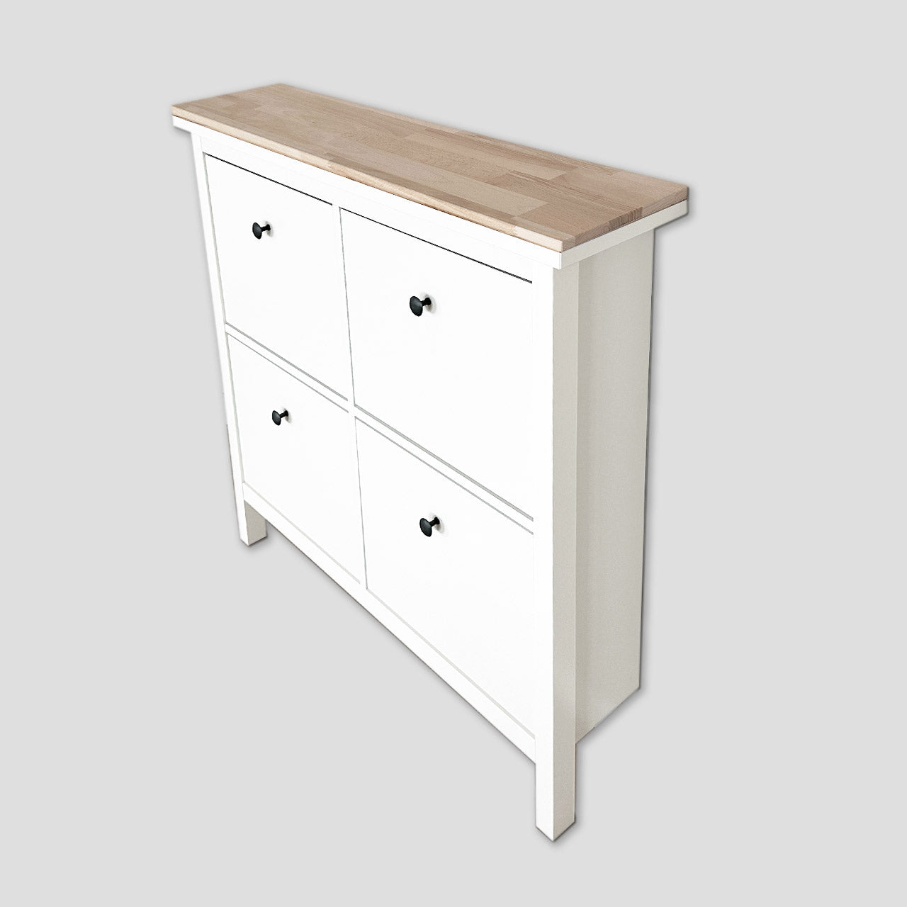 Auf einem weißen Ikea Hemnes Schuhschrank mit 4 Fächern liegt eine natur belassene Holzplatte aus Buchenholz.