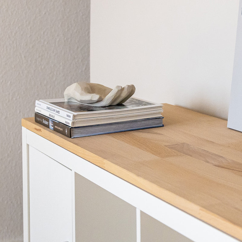 Auf einem weißen IKEA Kallax Regal liegt eine Vollholzplatte aus Buche.